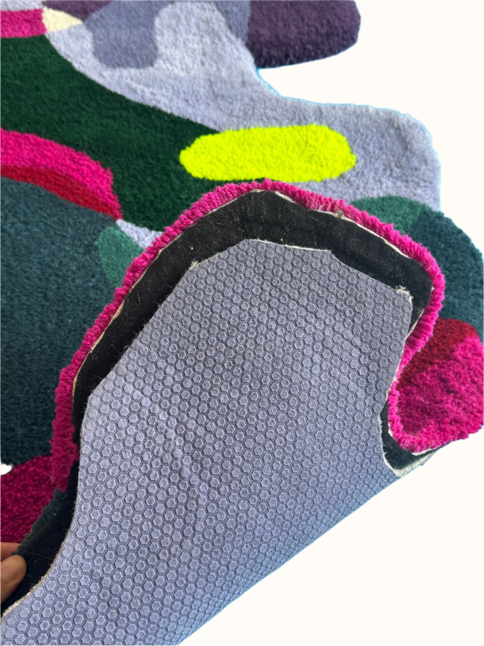 Close-up of a textured rug with colorful patterns and antislip mat