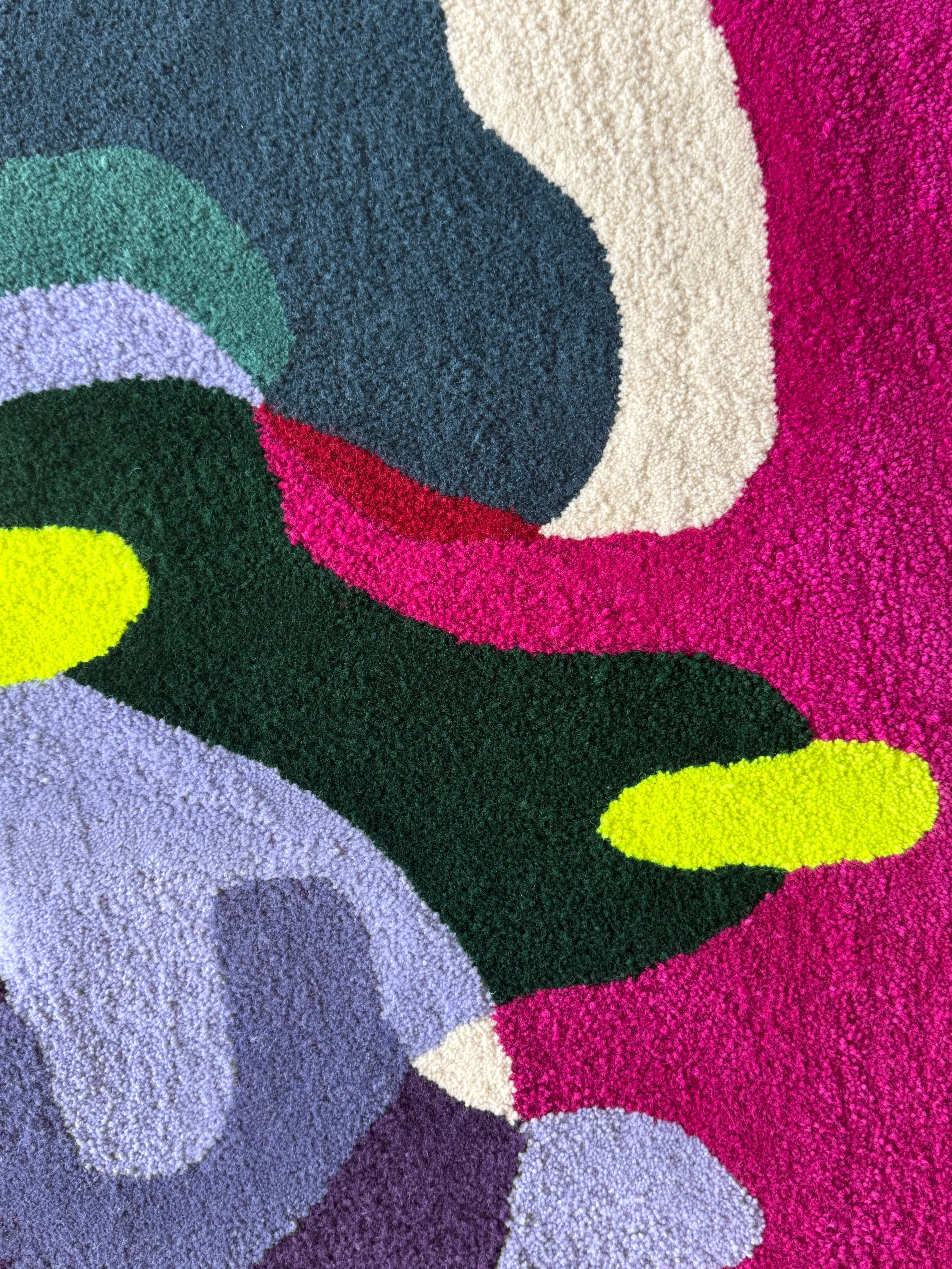 Colorful abstract rug with various shapes and colors on a pink background