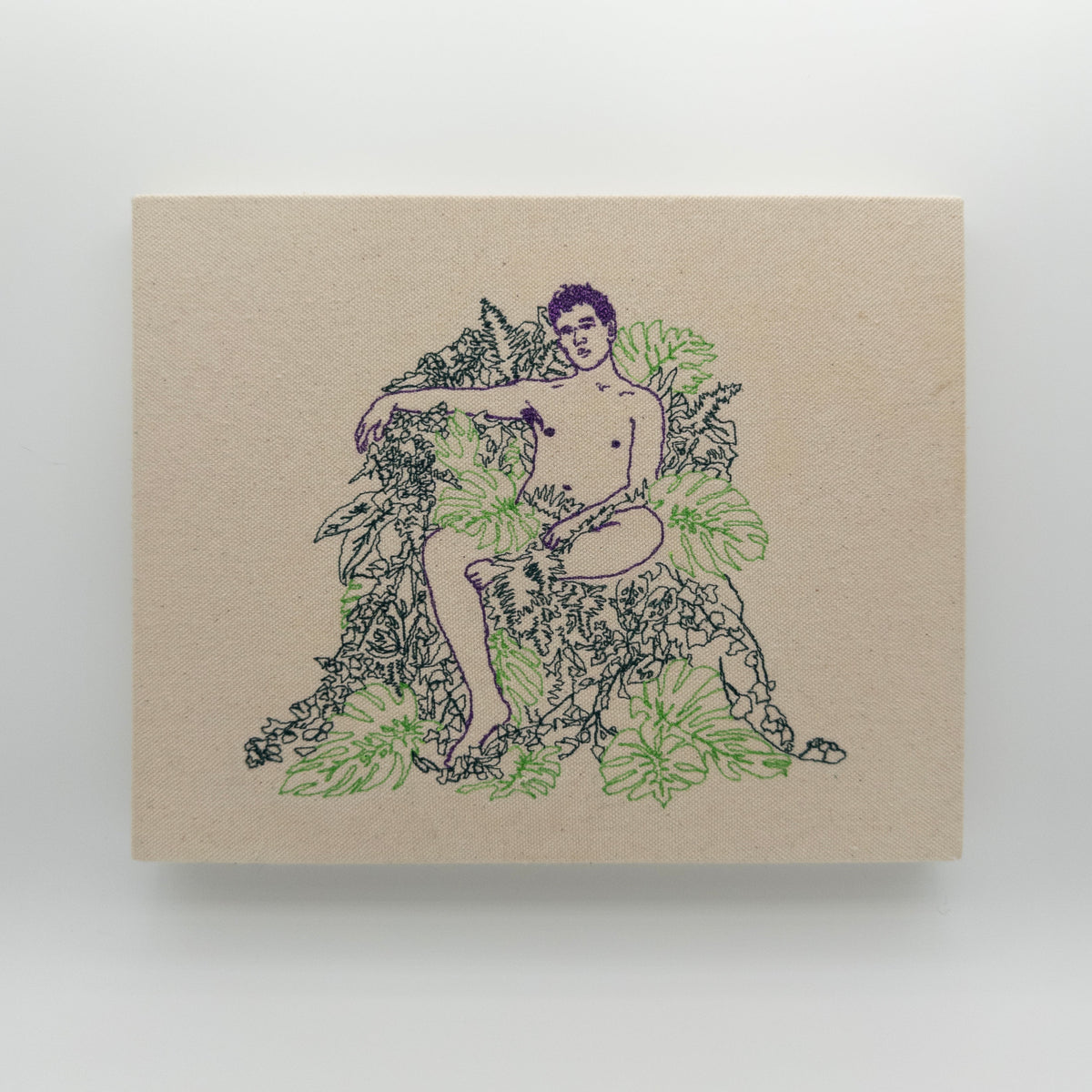 Basil: embroidered figure outlined in purple, seated among green monstera leaves, on natural canvas