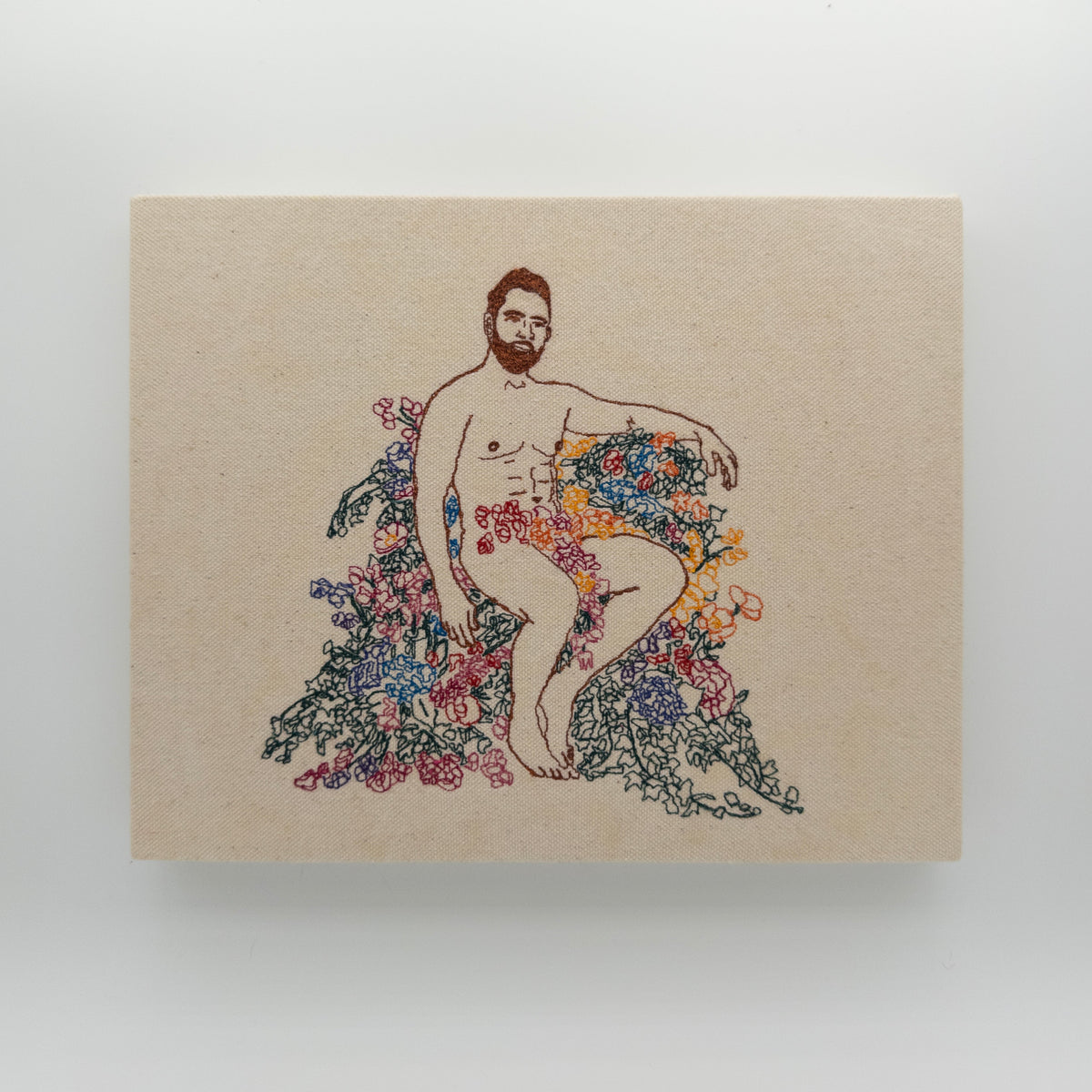 Bourbon: embroidered figure with an auburn beard, arm resting over a mound of flowers, on natural canvas