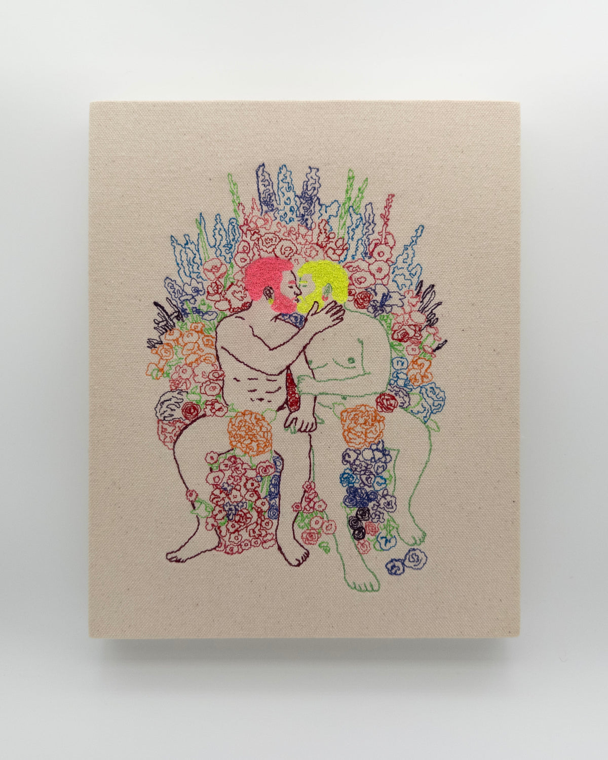 Sol & Rosé: two embroidered figures, one with pink hair and one with yellow, kissing among flowers, on natural canvas